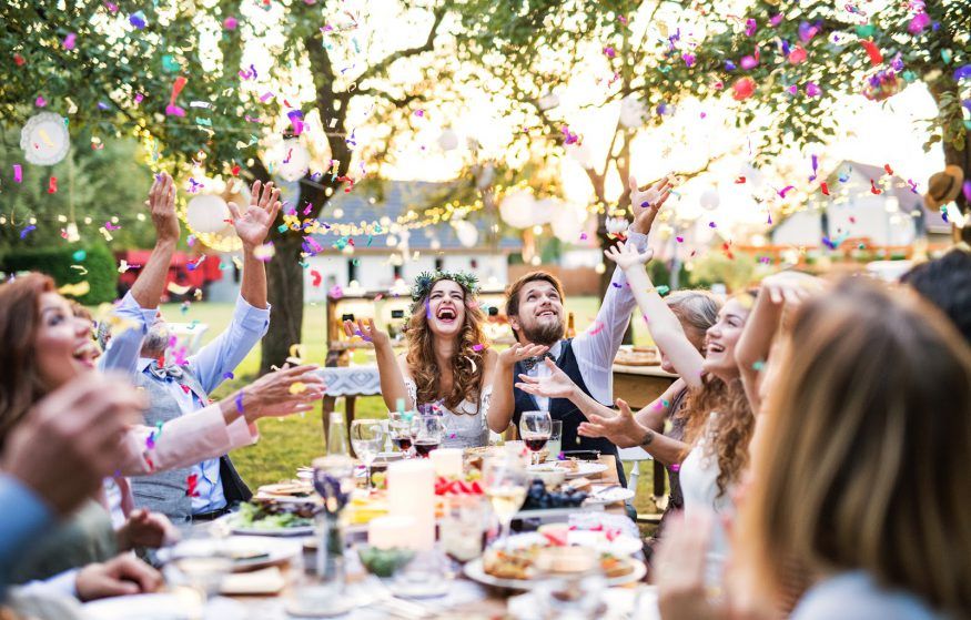 Wedding reception ideas: Guests throw confetti at an outdoor reception