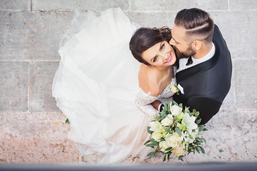 Elegant wedding invitations: groom kissing a bride